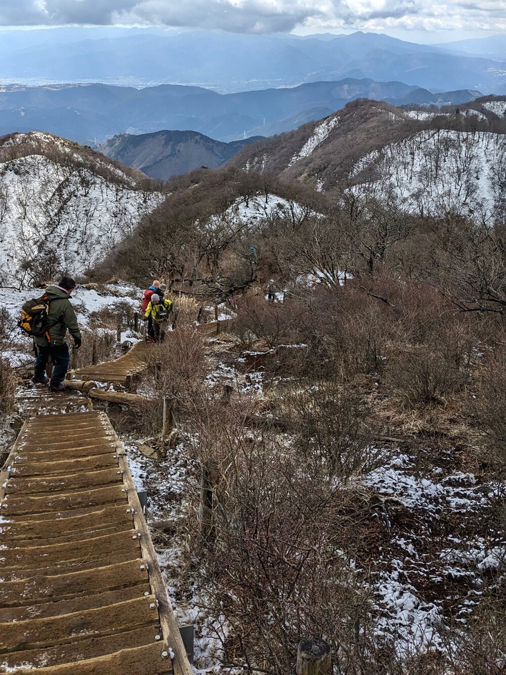 グリーン系のマウンテンパーカー、ブラック系のパンツ、ブラウン系のブーツを着用したメンズの春コーディネートの4枚目の写真