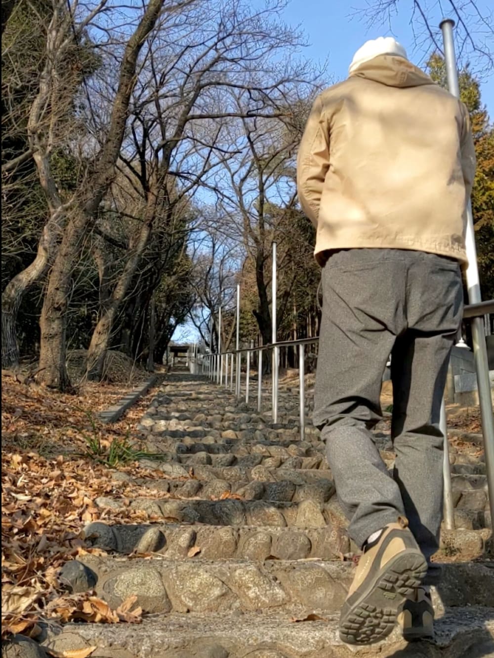 ベージュ系のマウンテンパーカー、ベージュ系のその他シューズ、グレー系のその他パンツを着用したメンズの春コーディネートの2枚目の写真