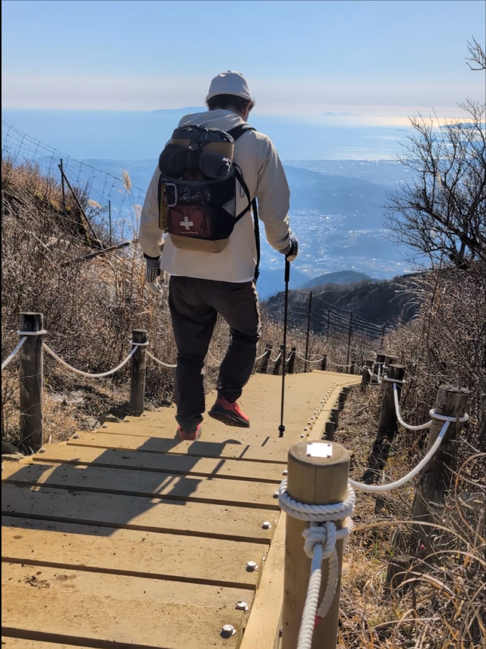 ベージュ系のパーカー、ブラウン系のパンツ、ブラウン系のバックパック/リュックを着用したメンズの冬コーディネートの4枚目の写真