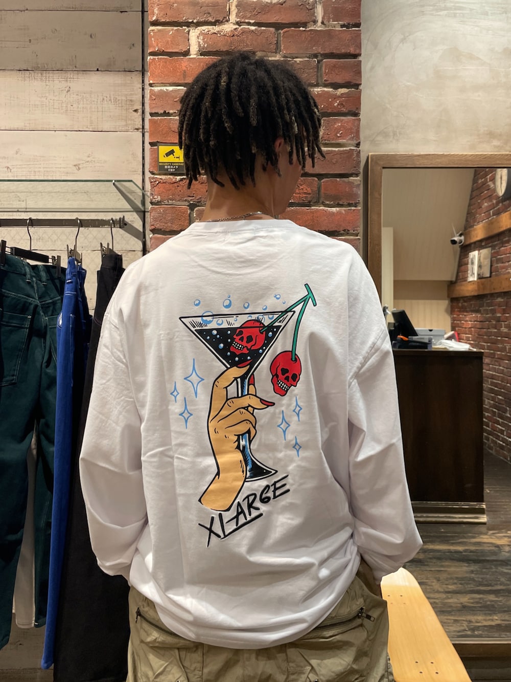 ブラウン系のカーゴパンツ、ホワイト系のTシャツ/カットソーを着用したメンズの夏コーディネートの2枚目の写真