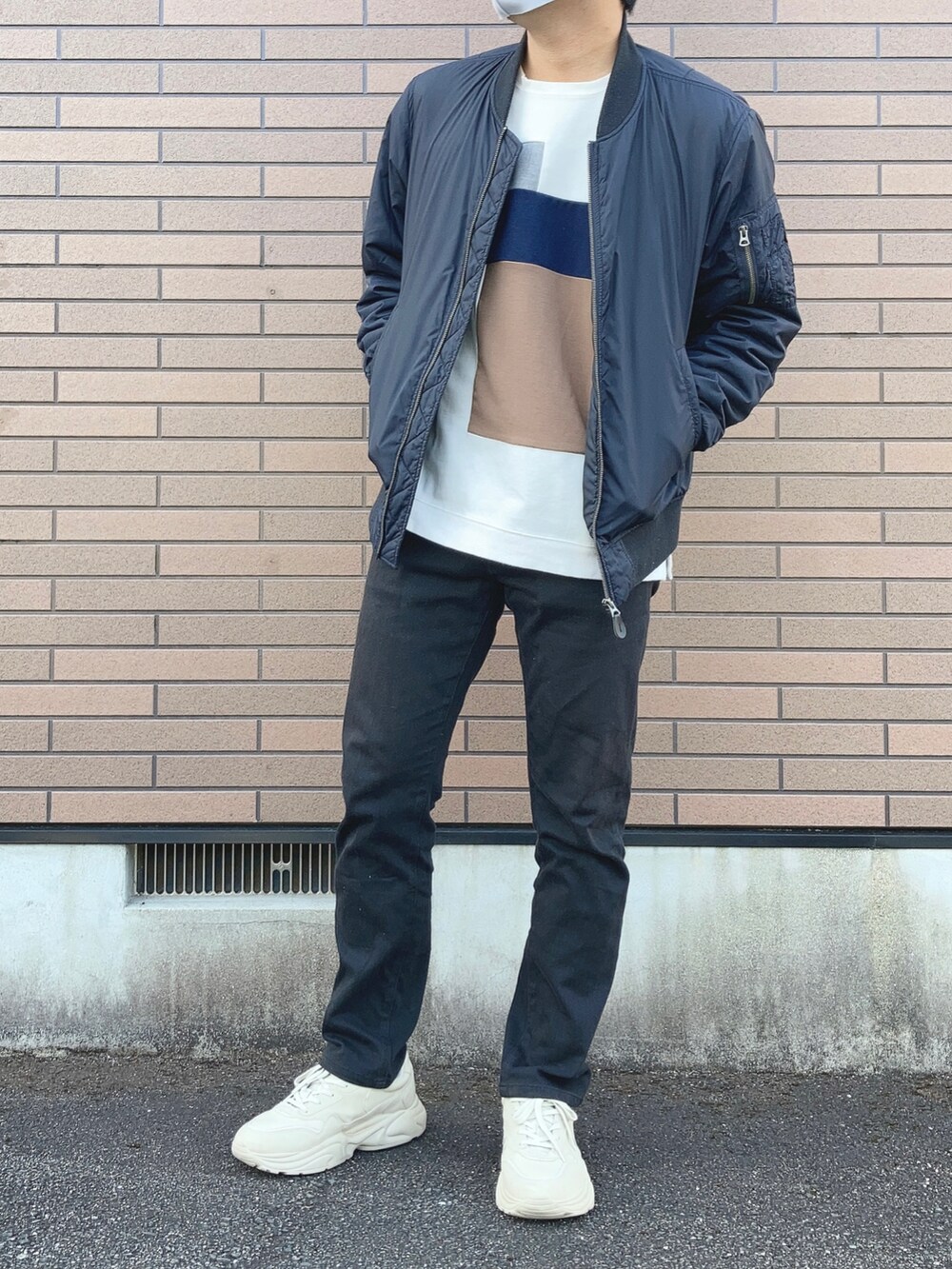 ブラック系のデニムパンツ、ホワイト系のスニーカー、ブルー系のブルゾンを着用したメンズの冬コーディネートの2枚目の写真