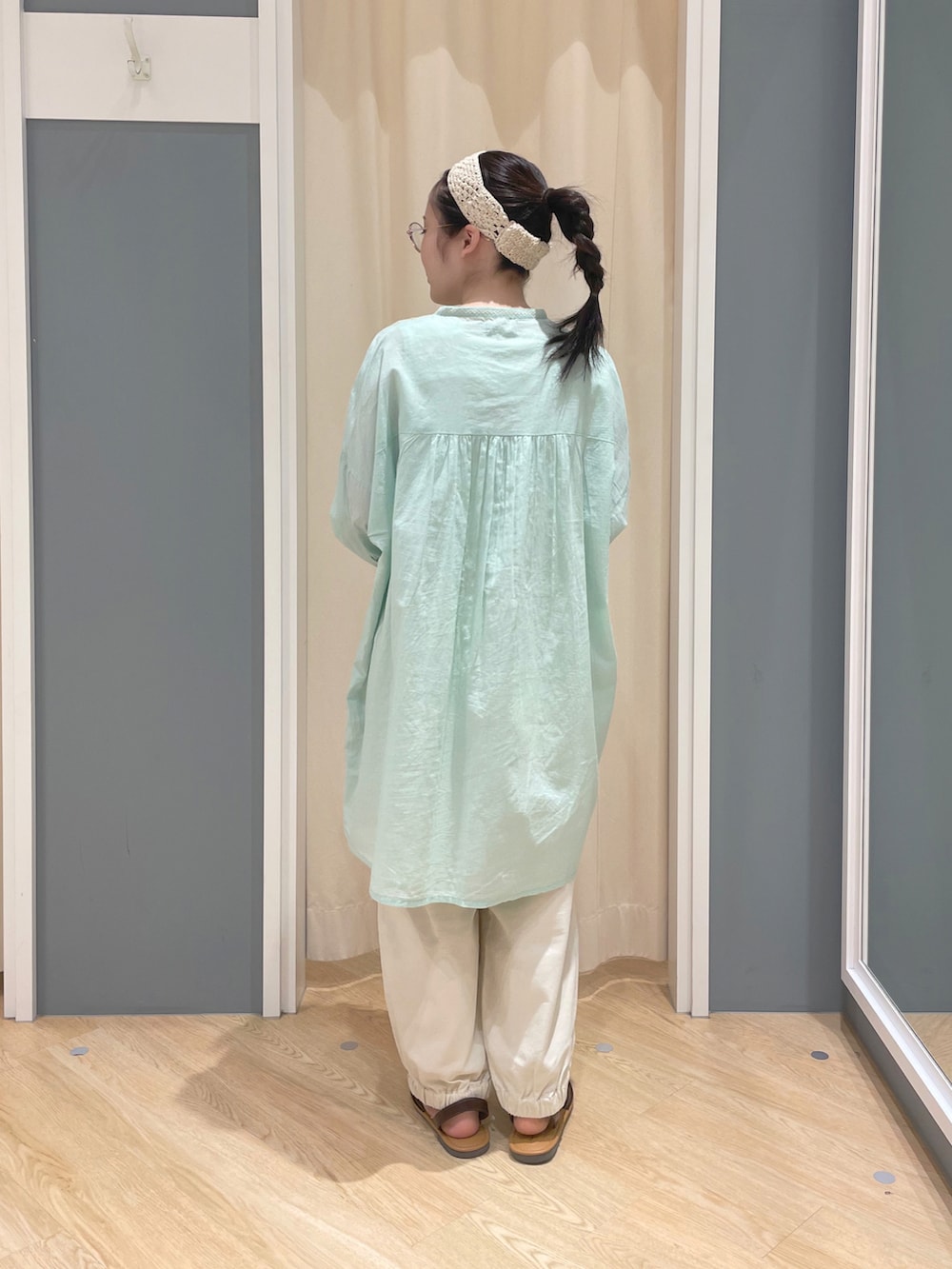 グリーン系のチュニック、ホワイト系のその他パンツ、ホワイト系のトートバッグを着用したレディースの春コーディネートの3枚目の写真