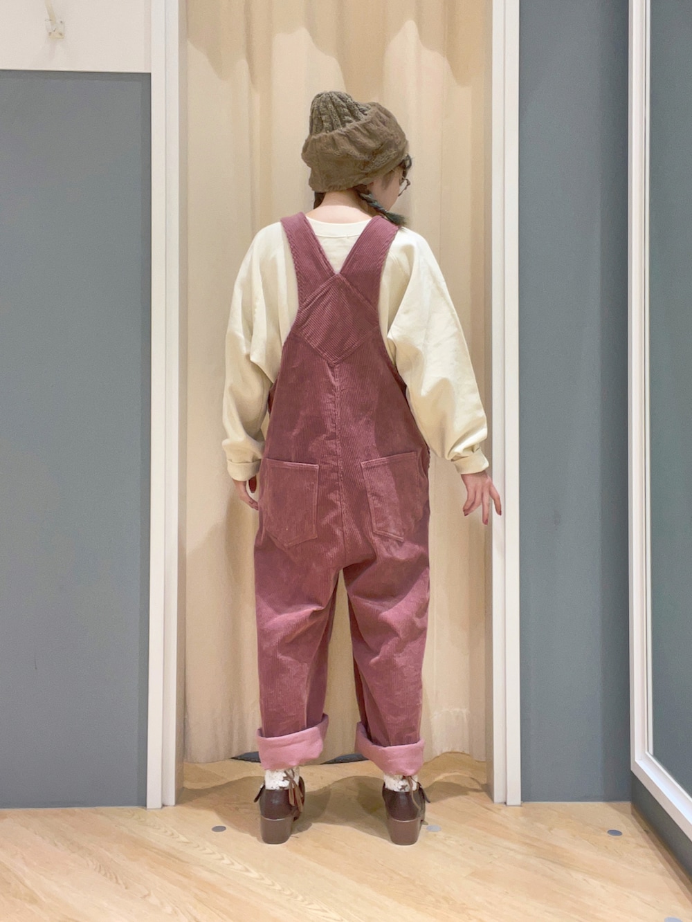 ピンク系のサロペット/オーバーオール、ホワイト系のスウェット、ブラウン系のサンダルを着用したレディースの秋コーディネートの2枚目の写真