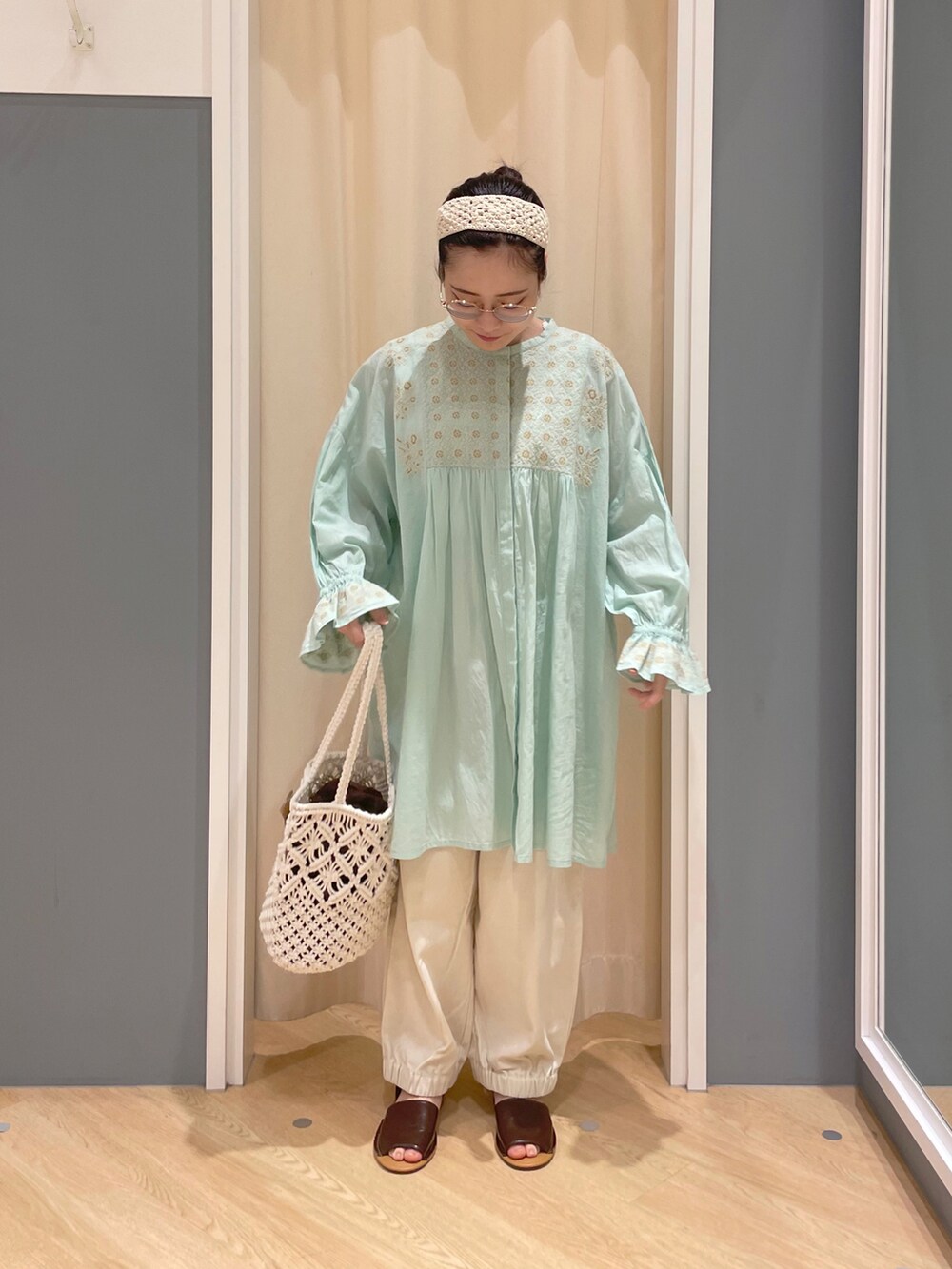 グリーン系のチュニック、ホワイト系のその他パンツ、ホワイト系のトートバッグを着用したレディースの春コーディネートの2枚目の写真