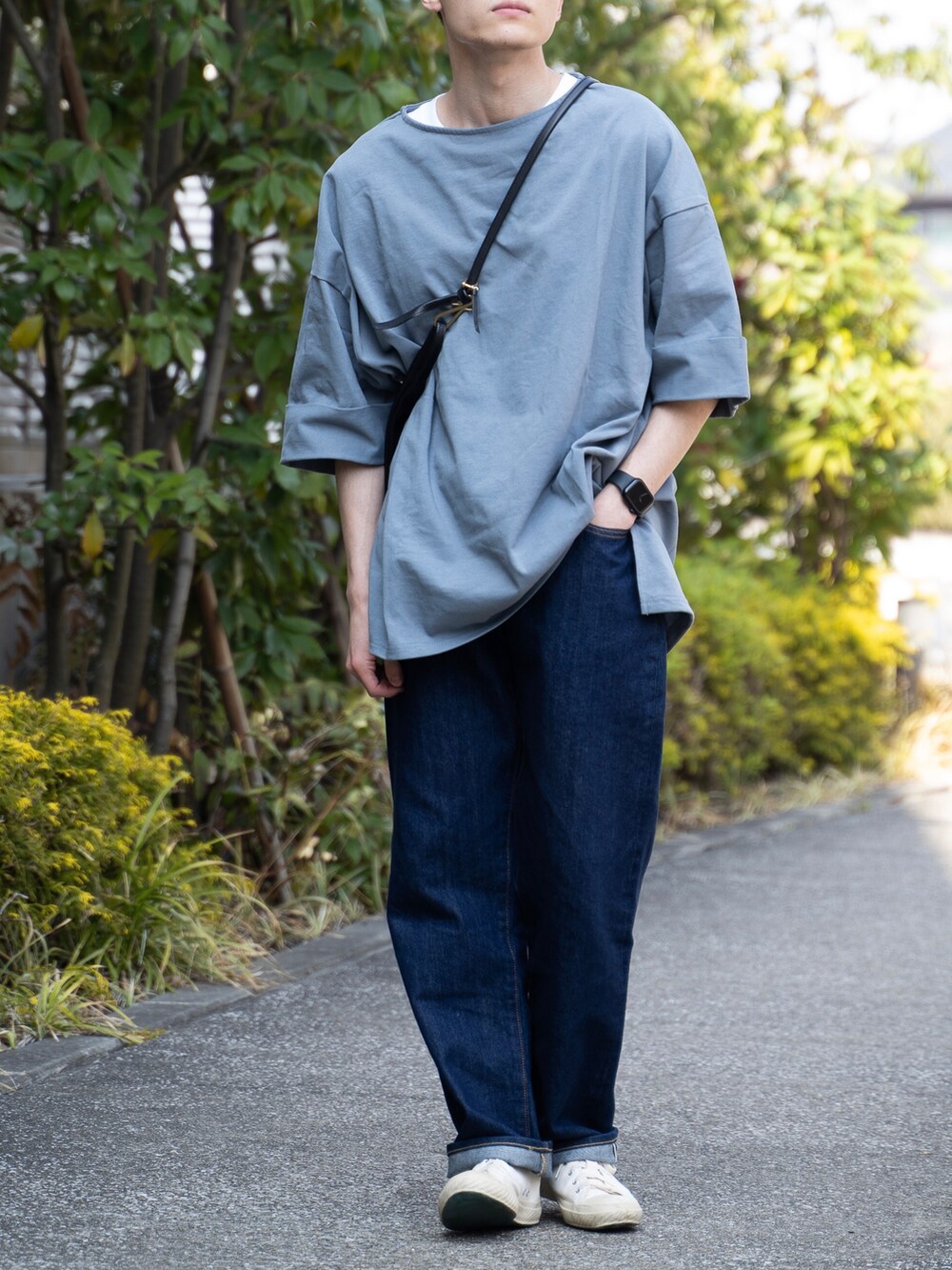 グレー系のTシャツ/カットソー、ブルー系のデニムパンツ、ホワイト系のスニーカーを着用したメンズの春コーディネートの2枚目の写真