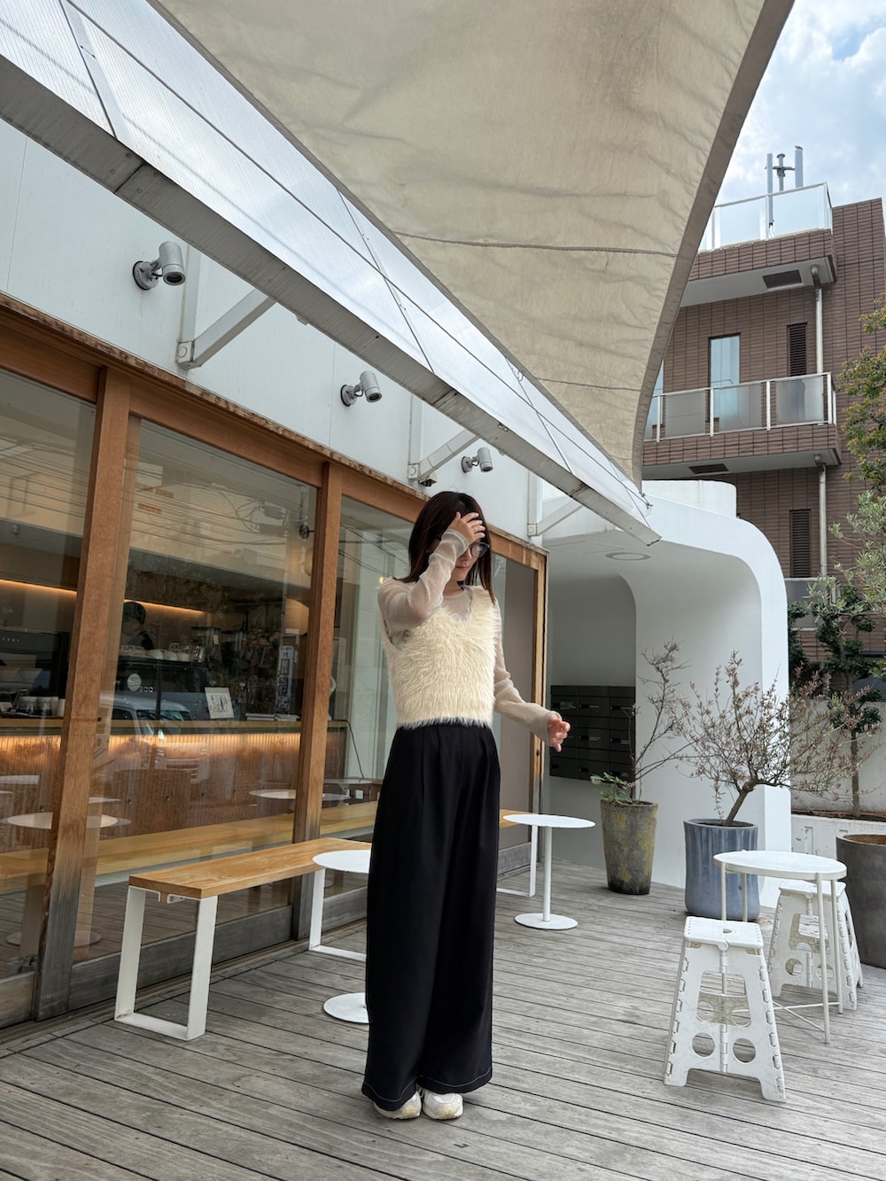 ベージュ系のTシャツ/カットソー、ブラック系のセットアップ、ホワイト系のベストを着用したレディースの秋コーディネートの2枚目の写真