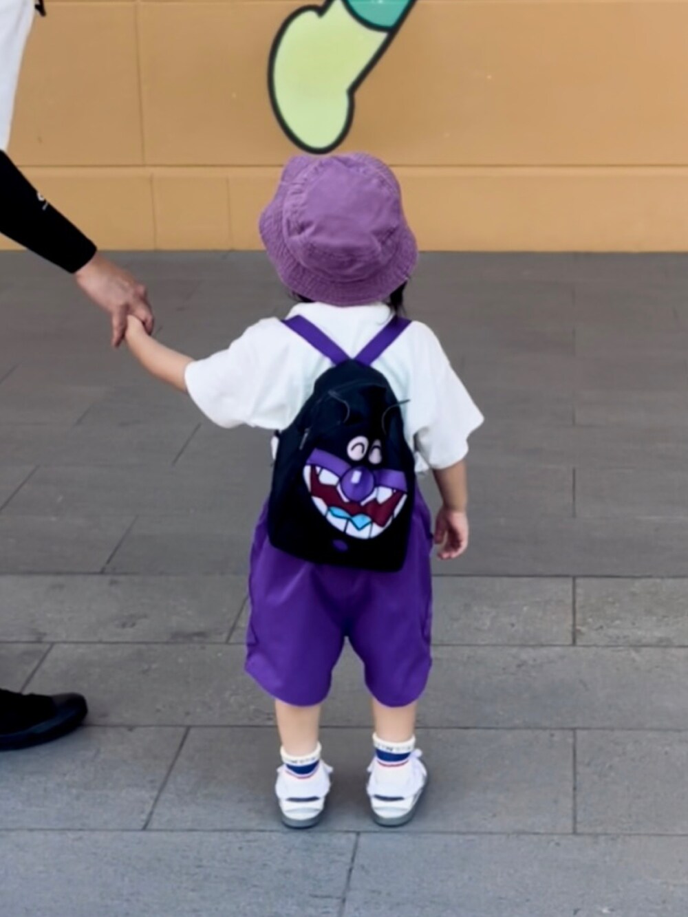 ホワイト系のトップス、パープル系のパンツ、ホワイト系のスニーカーを着用したキッズの夏コーディネートの2枚目の写真