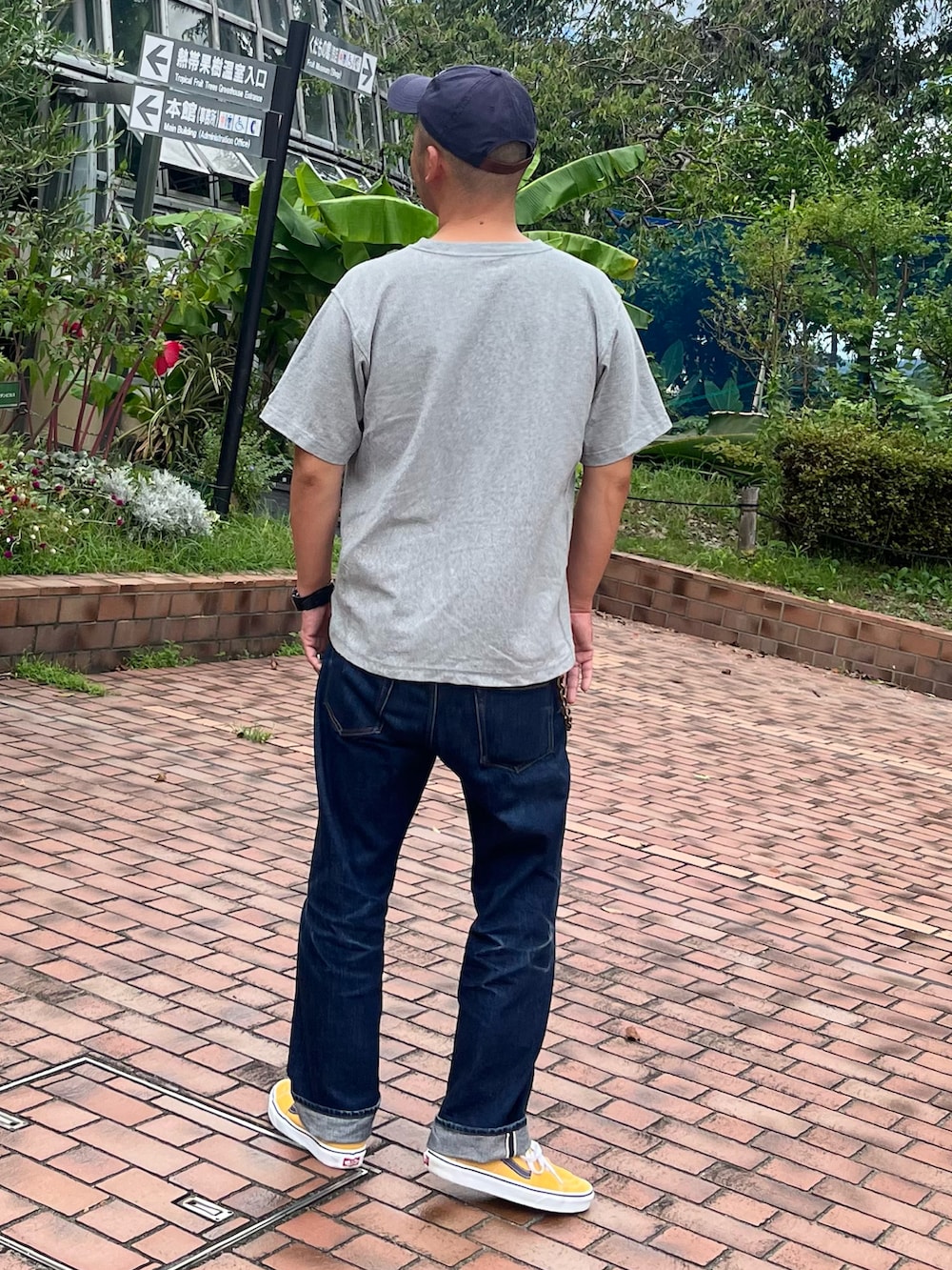 グレー系のTシャツ/カットソー、ブルー系のデニムパンツ、イエロー系のスニーカーを着用したメンズの秋コーディネートの3枚目の写真