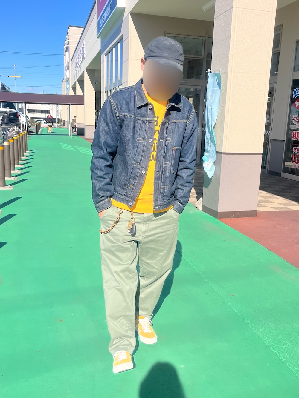 ブルー系のデニムジャケット、イエロー系のスウェット、グリーン系のチノパンツを着用したメンズの冬コーディネートの2枚目の写真