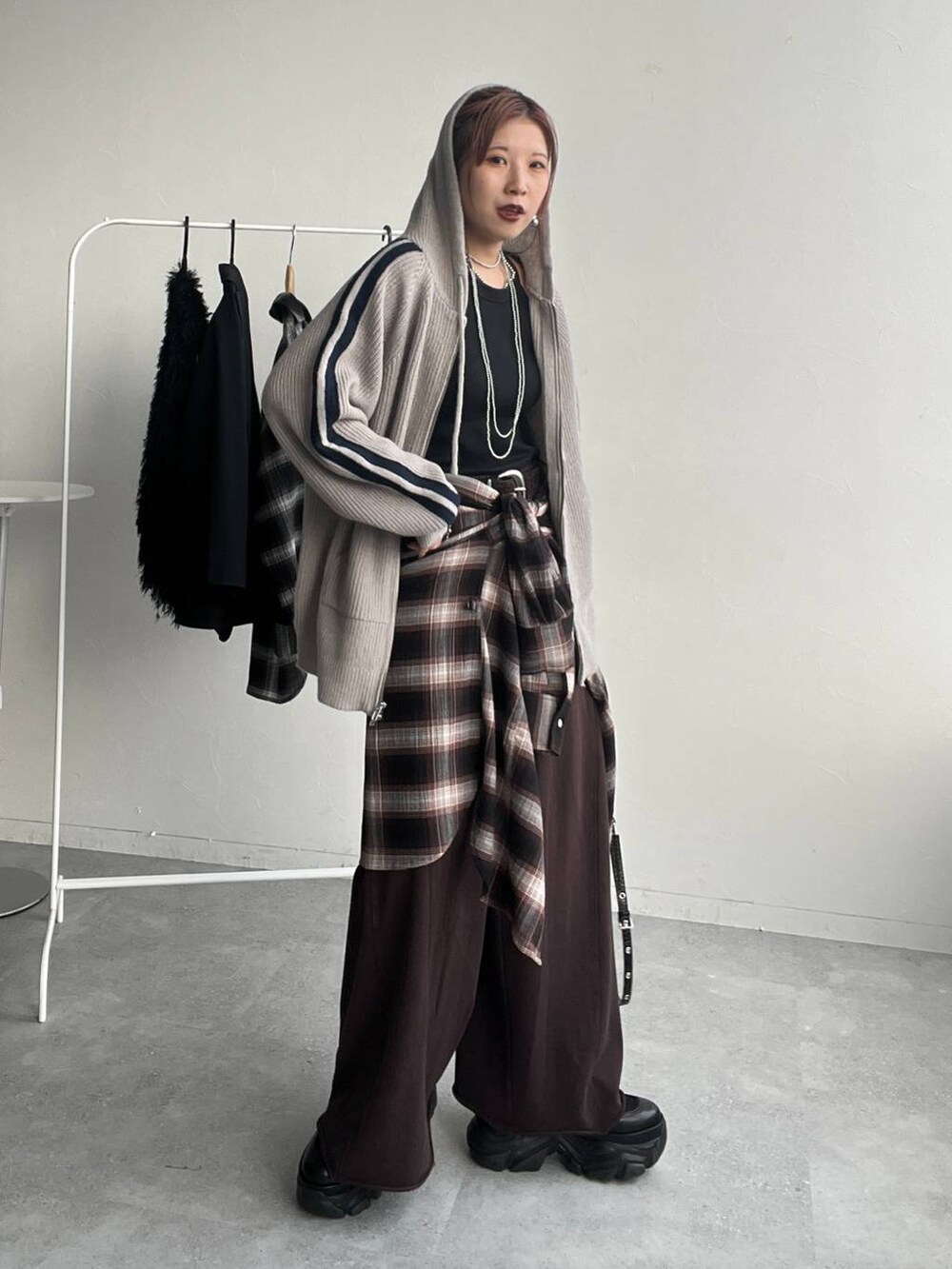 ブラウン系のシャツ/ブラウス、ブラウン系のスウェットパンツ、ブラック系のハンドバッグを着用したレディースの秋コーディネートの2枚目の写真