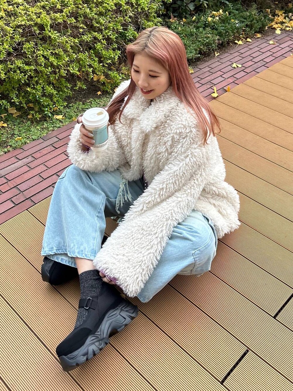 パープル系のニット/セーター、ブラック系のスニーカー、ホワイト系のその他アウターを着用したレディースの冬コーディネートの5枚目の写真