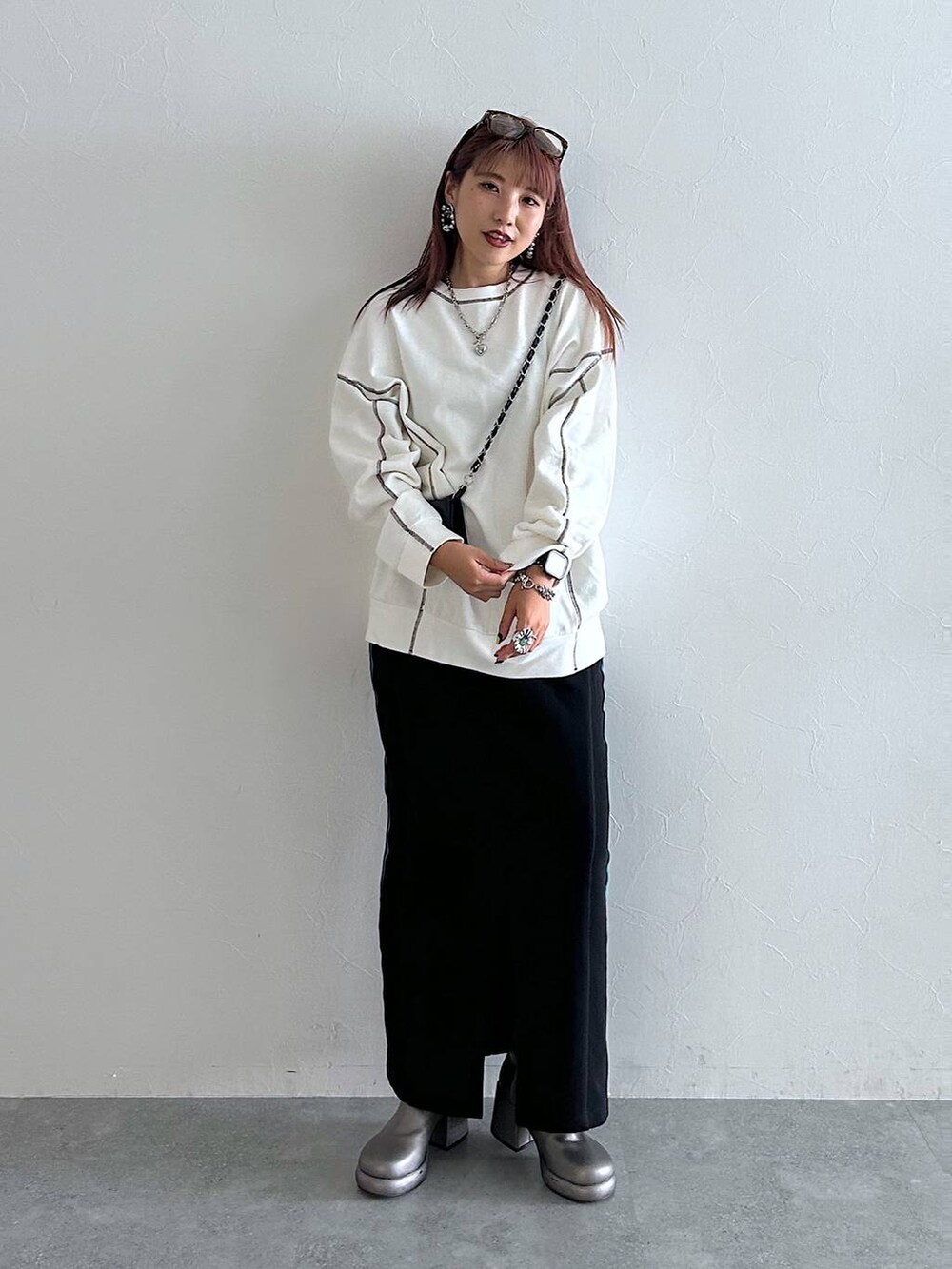 ホワイト系のスウェット、その他のブーツ、ブラック系のスカートを着用したレディースの秋コーディネートの2枚目の写真