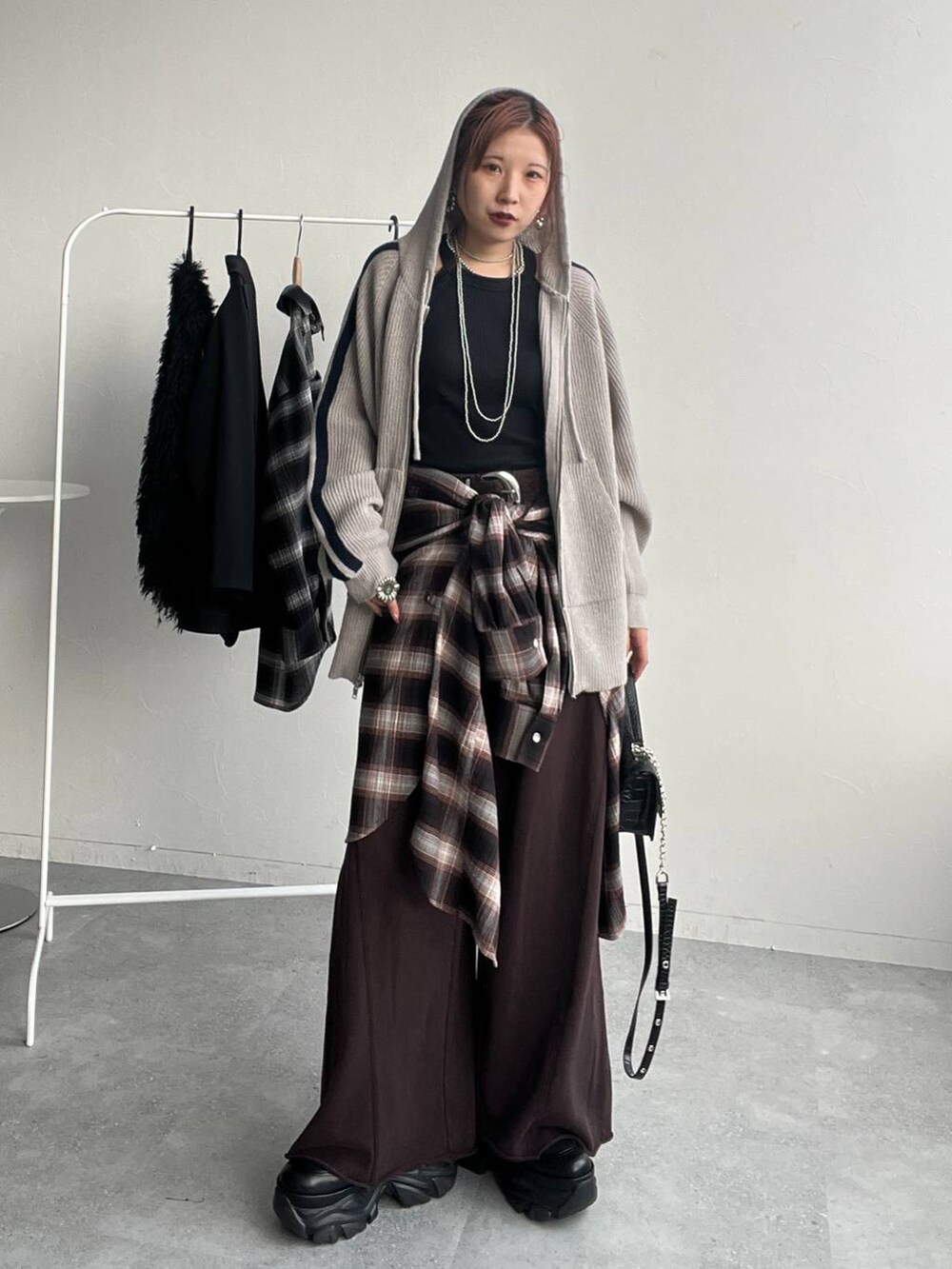 ブラウン系のシャツ/ブラウス、ブラウン系のスウェットパンツ、ブラック系のハンドバッグを着用したレディースの秋コーディネートの3枚目の写真
