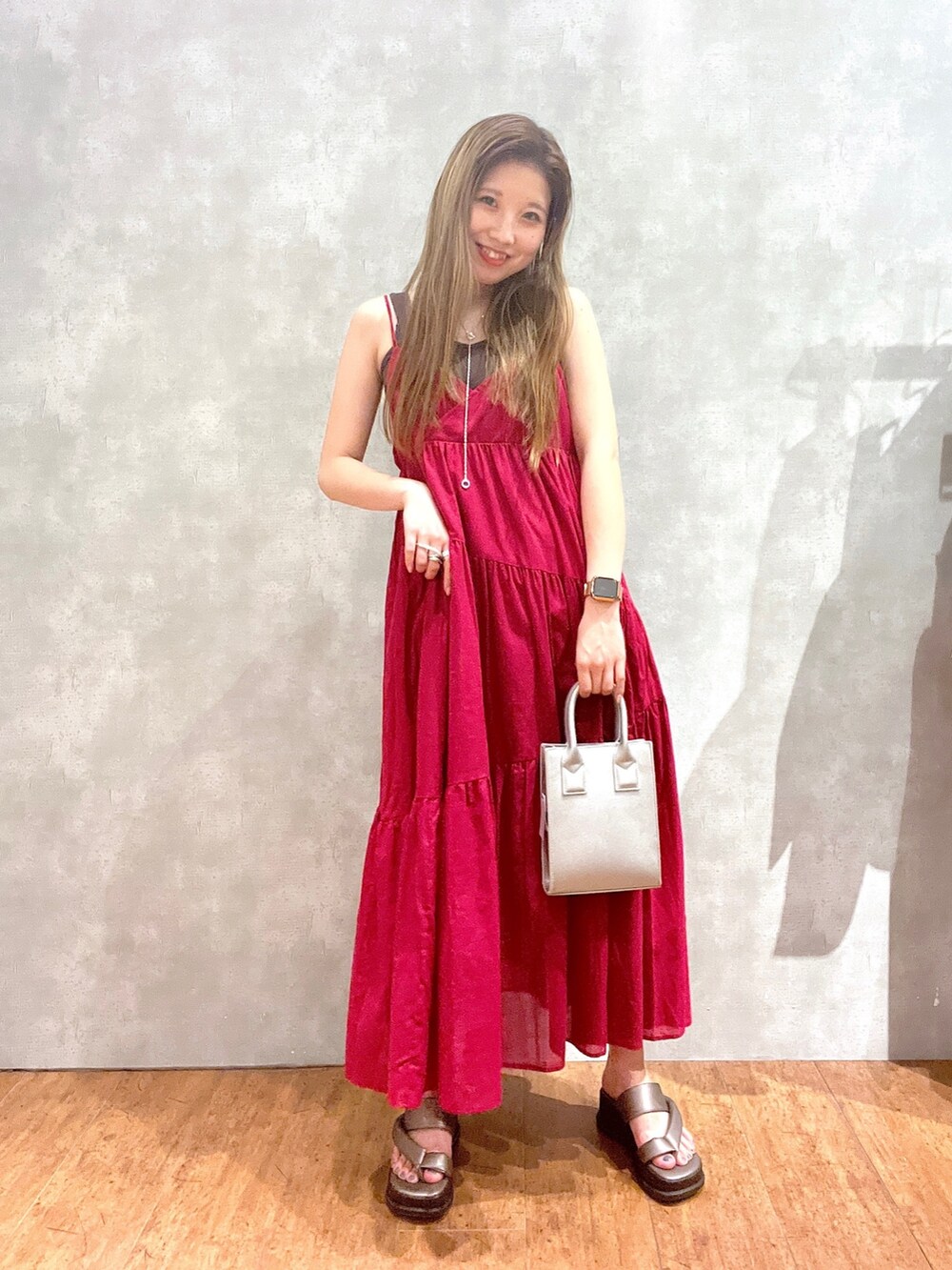 ブラック系のバッグ、ピンク系のワンピース、その他のサンダルを着用したレディースの春コーディネートの2枚目の写真