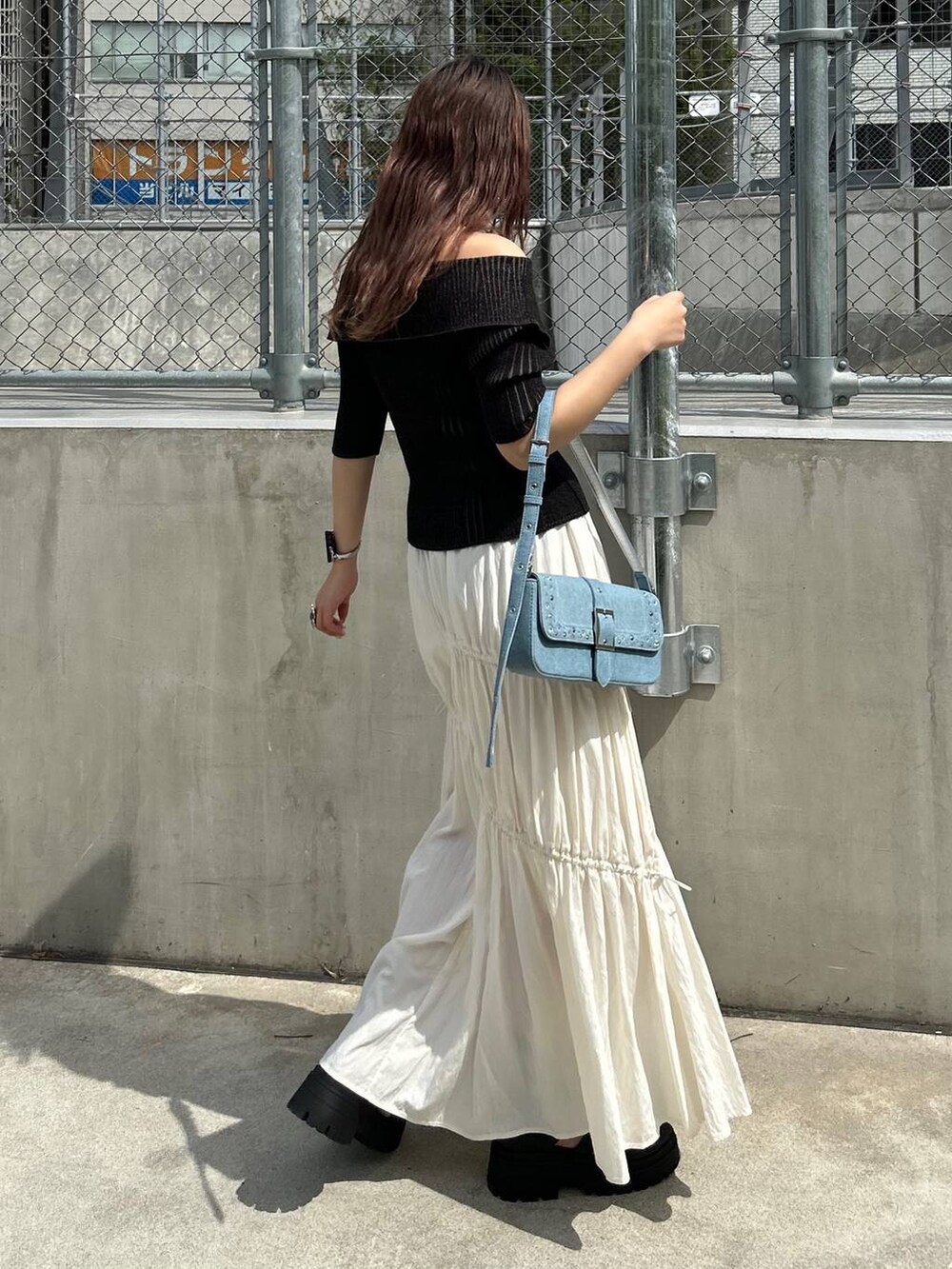 ブラック系のサンダル、ホワイト系のスカート、ブラック系のニット/セーターを着用したレディースの夏コーディネートの2枚目の写真