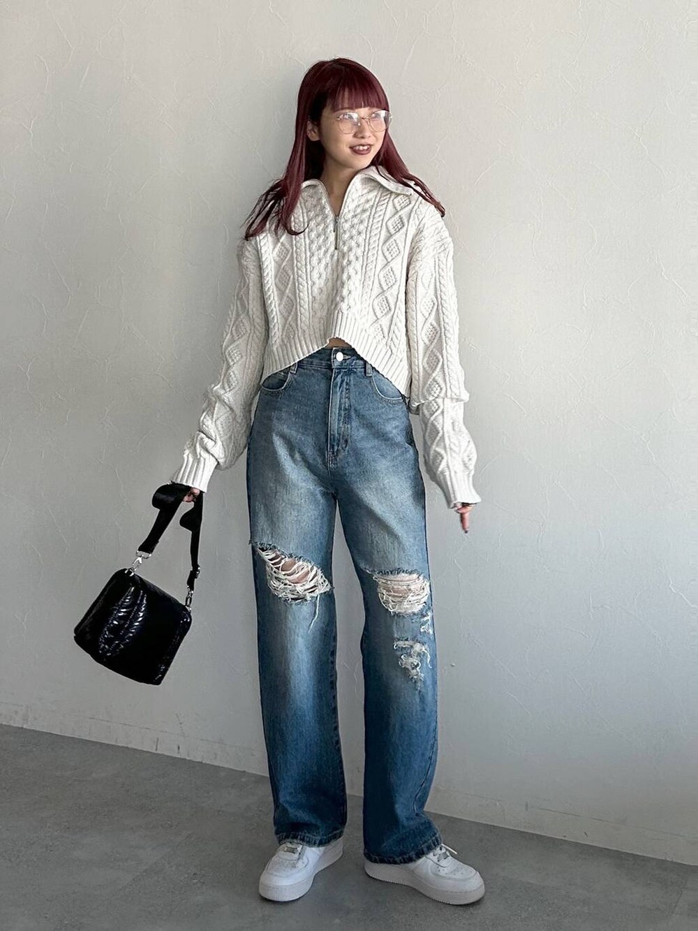 ブルー系のデニムパンツ、ブラック系のショルダーバッグ、グレー系のニット/セーターを着用したレディースの冬コーディネートの2枚目の写真