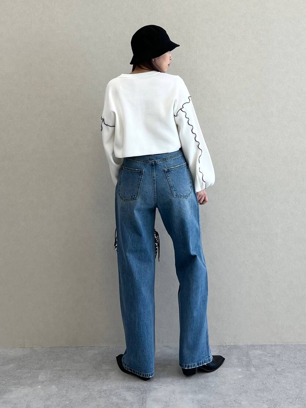 ブラック系のキャミソール、ブルー系のデニムパンツ、シルバー系のショルダーバッグを着用したレディースの春コーディネートの2枚目の写真