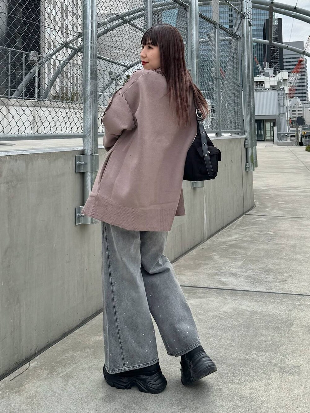 ホワイト系のキャミソール、ブラウン系のカーディガン/ボレロ、ブラック系のデニムパンツを着用したレディースの春コーディネートの3枚目の写真