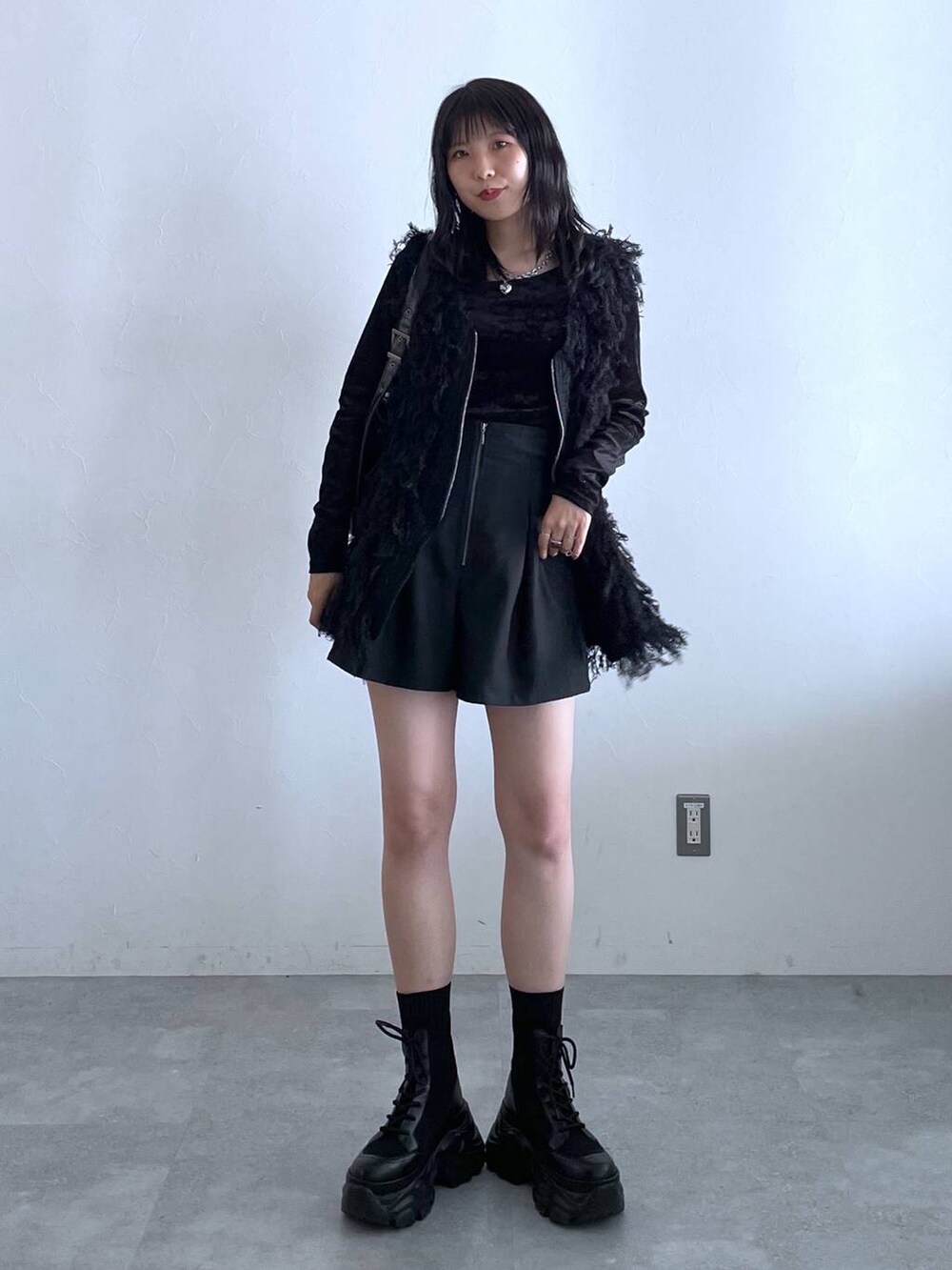 ブラック系のブーツ、ブラック系のショルダーバッグ、ブラック系のその他パンツを着用したレディースの秋コーディネートの2枚目の写真