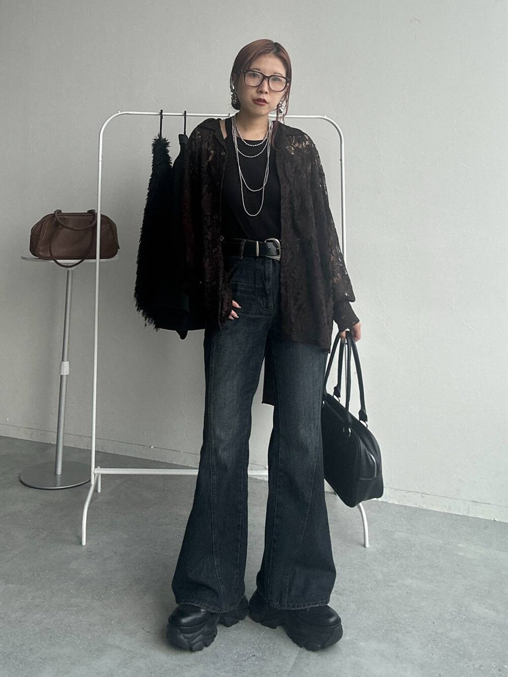 ブラック系のスニーカー、ブルー系のデニムパンツ、ブラウン系のシャツ/ブラウスを着用したレディースの秋コーディネートの4枚目の写真