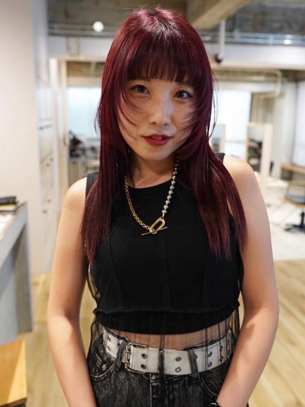 ブラック系のデニムパンツ、ブラック系のタンクトップ、ブラック系のワンピースを着用したレディースの冬コーディネートの3枚目の写真