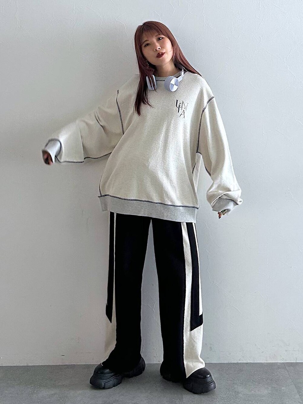 ブラック系のスウェットパンツ、グレー系のスウェット、ブラック系のブーツを着用したレディースの秋コーディネートの4枚目の写真