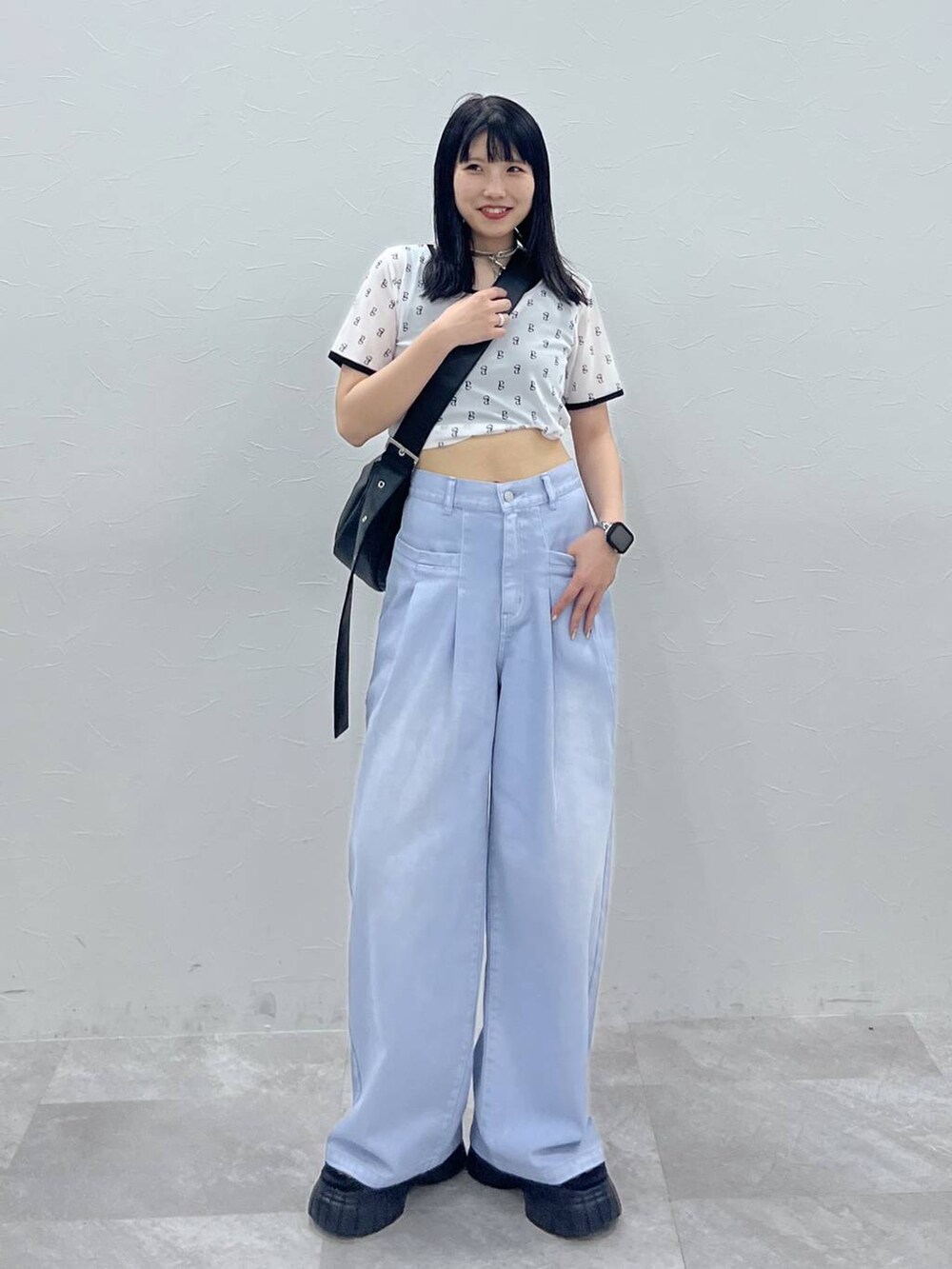 ブラック系のスニーカー、ブルー系のデニムパンツ、ホワイト系のTシャツ/カットソーを着用したレディースの夏コーディネートの2枚目の写真