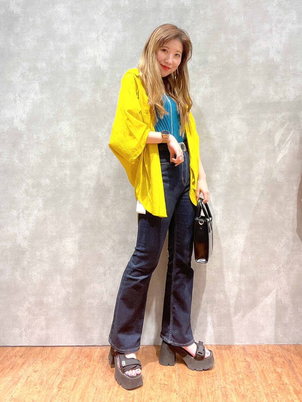 イエロー系のシャツ/ブラウス、グリーン系のタンクトップ、ブラック系のデニムパンツを着用したレディースの夏コーディネートの3枚目の写真