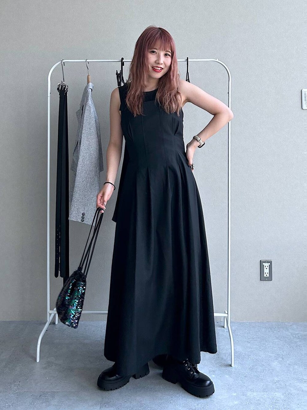 ブラック系のショルダーバッグ、ブラック系のブーツ、ブラック系のジャンパースカートを着用したレディースの秋コーディネートの2枚目の写真