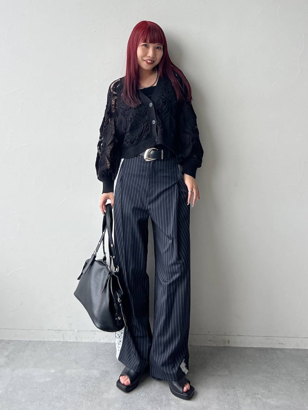 ブラック系のカーディガン/ボレロ、ブルー系のその他パンツ、ブラック系のトートバッグを着用したレディースの春コーディネートの2枚目の写真