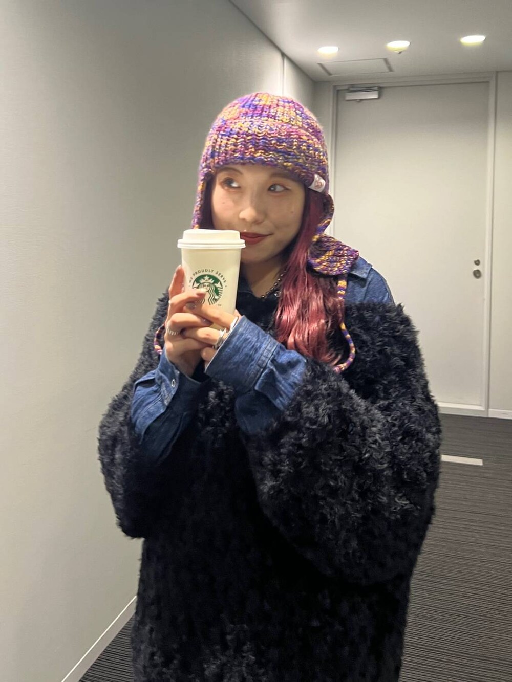 ブルー系のシャツ/ブラウス、ブラック系のブーツ、ブラック系のニット/セーターを着用したレディースの冬コーディネートの3枚目の写真