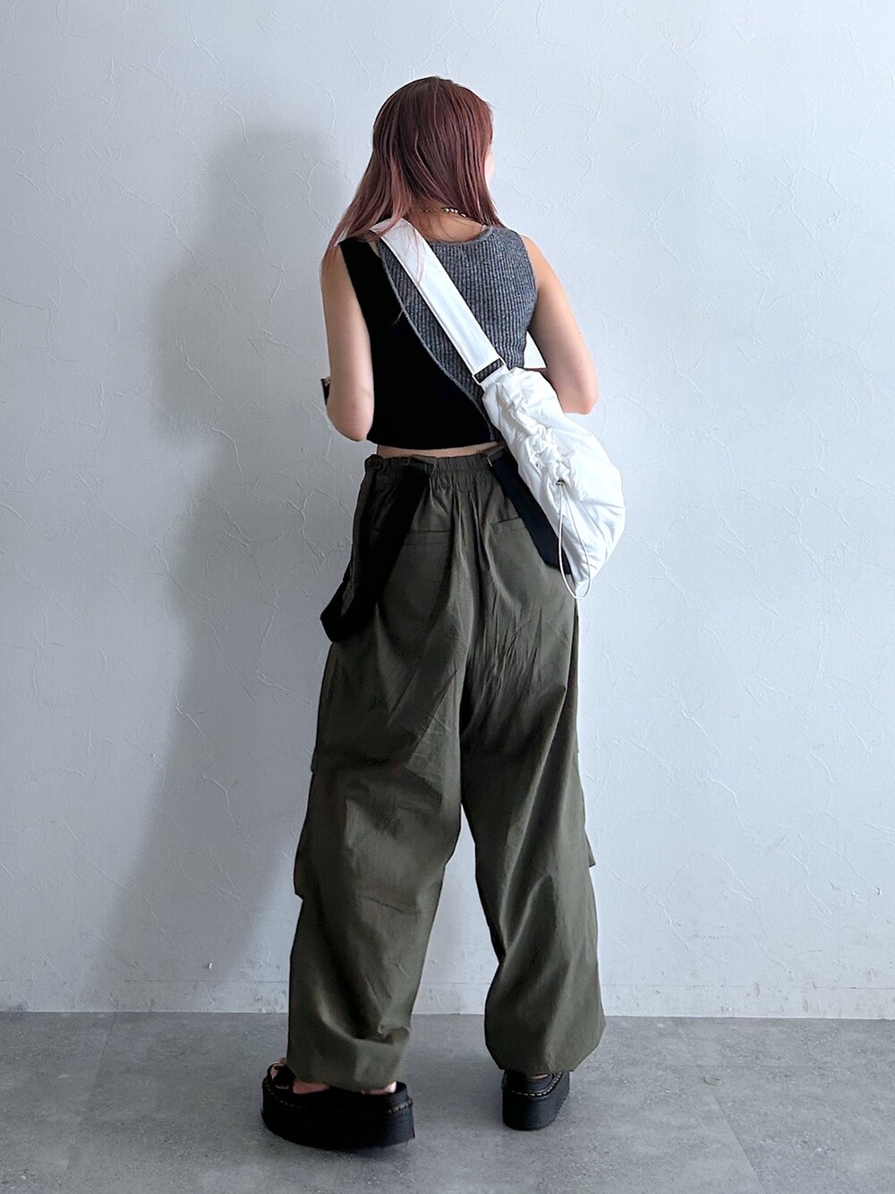 グリーン系のその他パンツ、ブラック系のタンクトップ、ホワイト系のショルダーバッグを着用したレディースの秋コーディネートの2枚目の写真