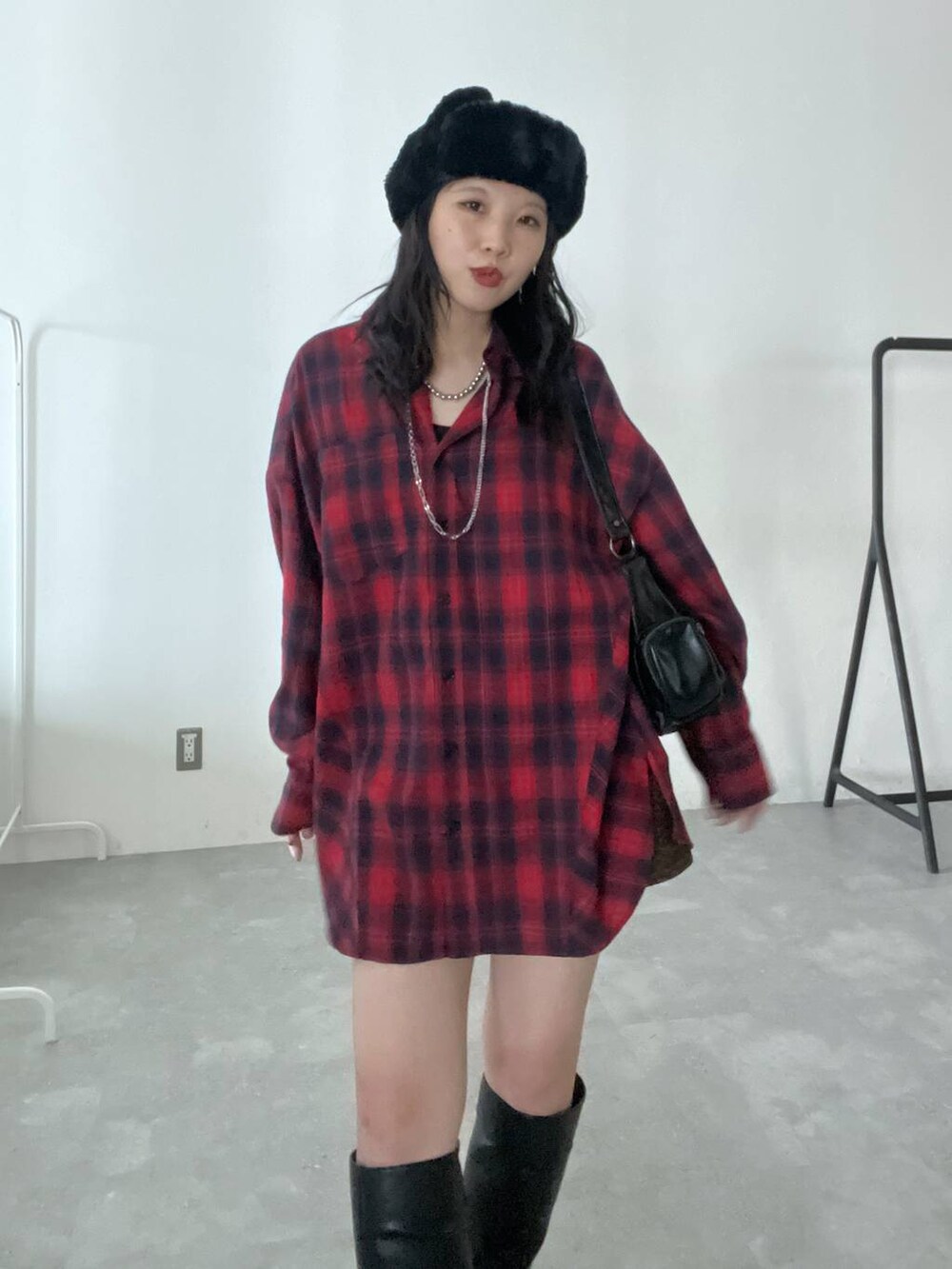 ブラック系のショルダーバッグ、その他のスカート、ブラック系のブーツを着用したレディースの秋コーディネートの2枚目の写真