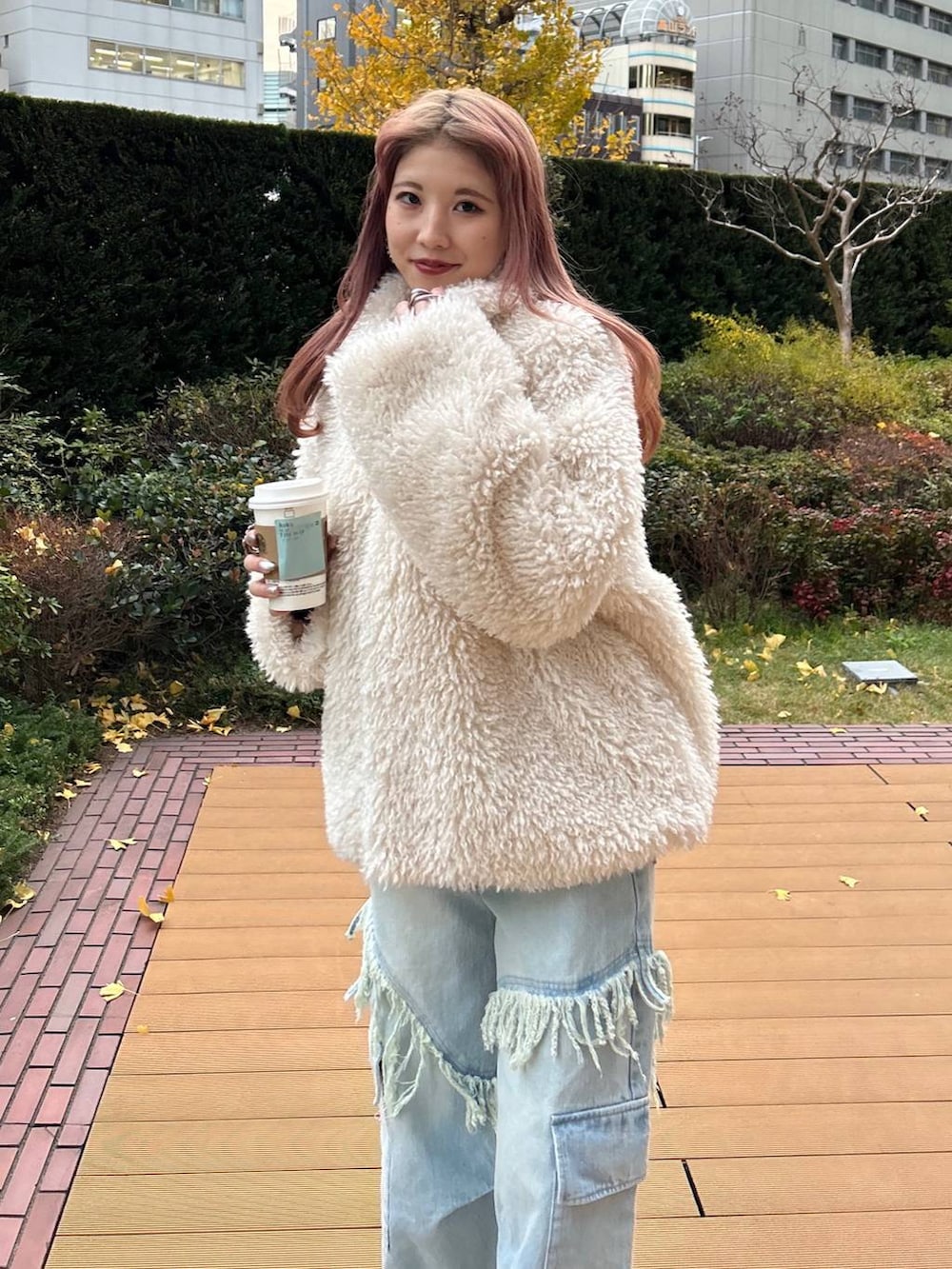 パープル系のニット/セーター、ブラック系のスニーカー、ホワイト系のその他アウターを着用したレディースの冬コーディネートの3枚目の写真