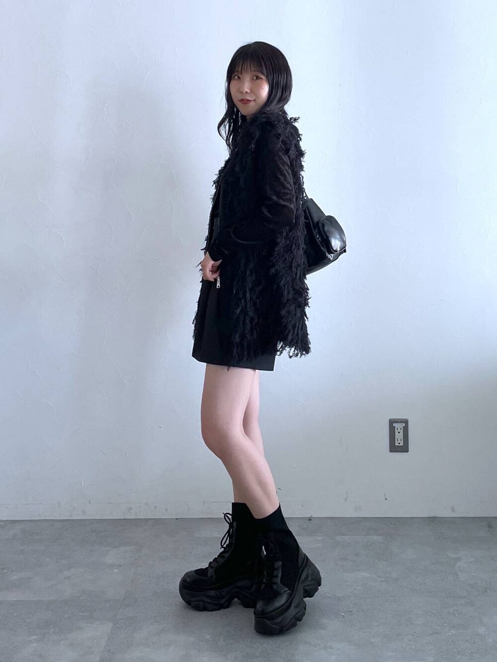 ブラック系のブーツ、ブラック系のショルダーバッグ、ブラック系のその他パンツを着用したレディースの秋コーディネートの3枚目の写真