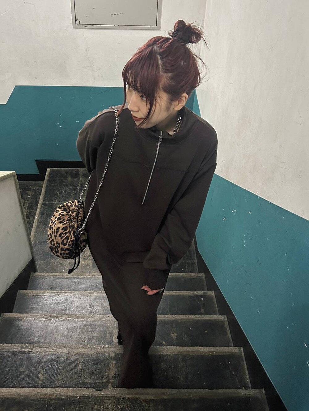 その他のハンドバッグ、ブラック系のブーツ、ブラウン系のワンピースを着用したレディースの秋コーディネートの2枚目の写真