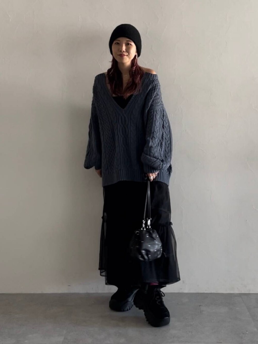 ブラック系のキャミソール、ブラック系のデニムパンツ、ブルー系のニット/セーターを着用したレディースの秋コーディネートの3枚目の写真