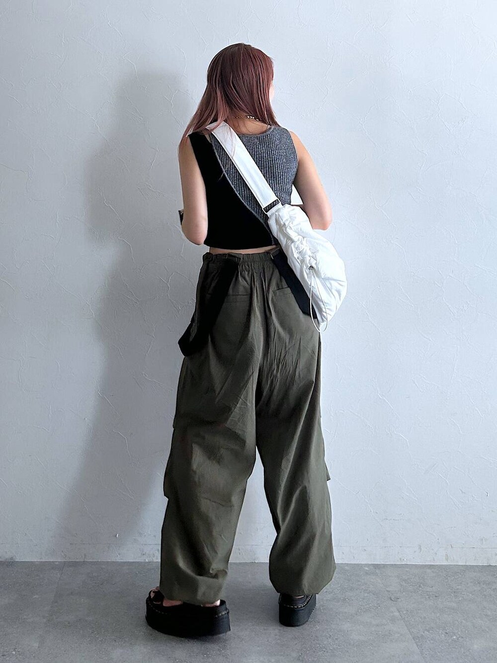 グリーン系のその他パンツ、ホワイト系のショルダーバッグ、ブラック系のタンクトップを着用したレディースの秋コーディネートの3枚目の写真