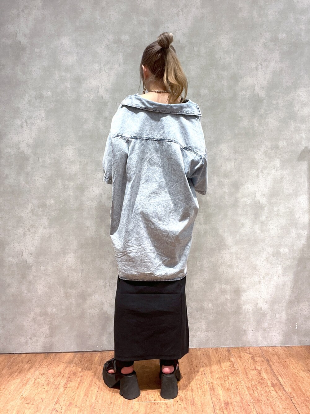 ブルー系のシャツ/ブラウス、ブラック系のスカート、グリーン系のショルダーバッグを着用したレディースの夏コーディネートの3枚目の写真