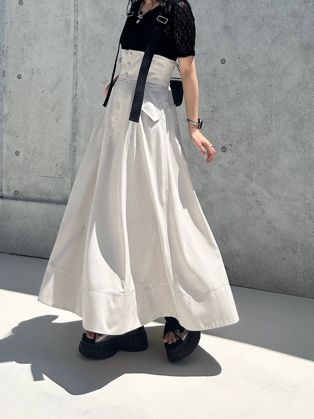 その他のスニーカー、ベージュ系のスカート、ブラック系のTシャツ/カットソーを着用したレディースの夏コーディネートの3枚目の写真