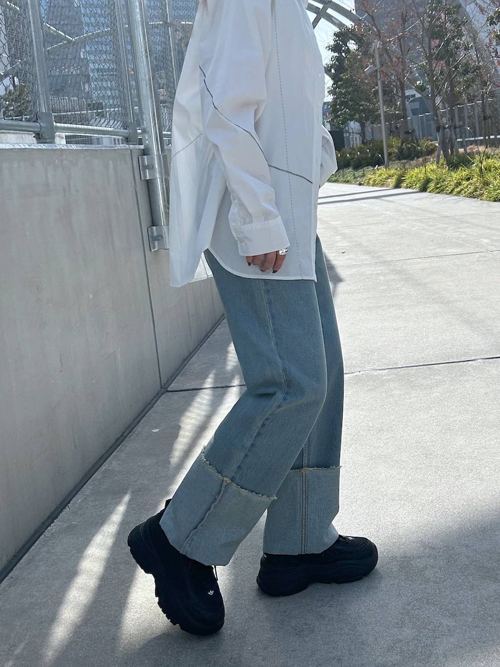 ホワイト系のシャツ/ブラウス、ホワイト系のキャミソール、ブラック系のスニーカーを着用したレディースの春コーディネートの4枚目の写真