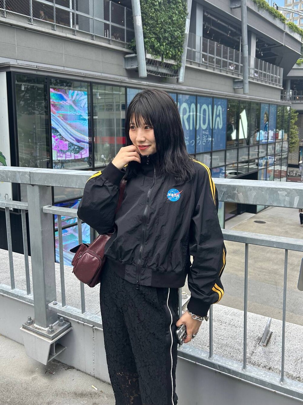 レッド系のショルダーバッグ、ブラック系のその他パンツを着用したレディースの秋コーディネートの2枚目の写真