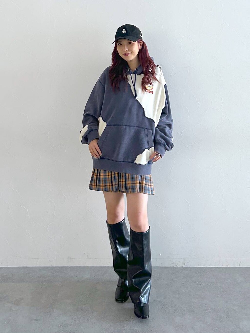 ブラック系のブーツ、ブルー系のパーカー、レッド系のスカートを着用したレディースの秋コーディネートの4枚目の写真