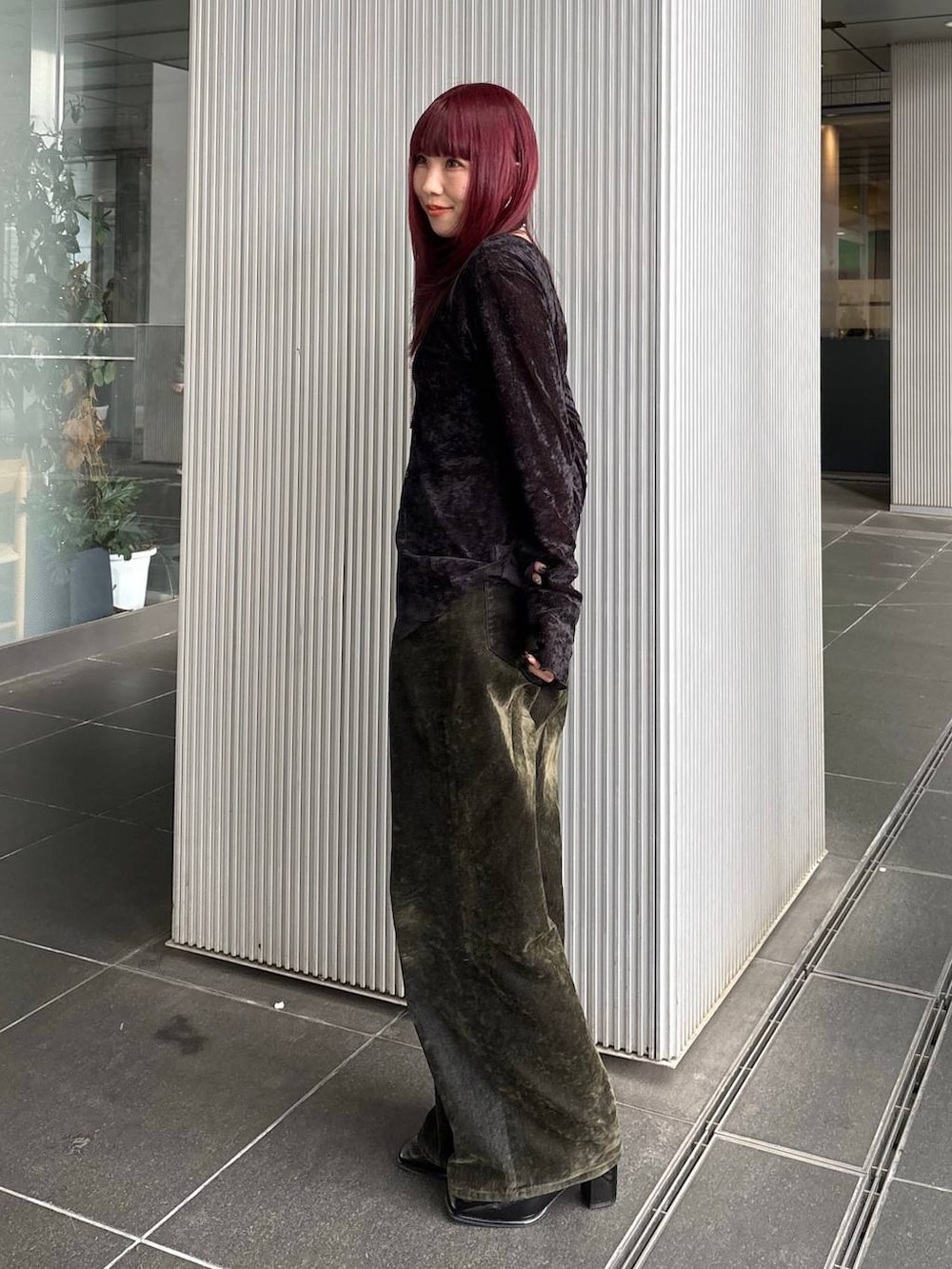 グリーン系のデニムパンツ、ブラック系のベルトを着用したレディースの冬コーディネートの2枚目の写真