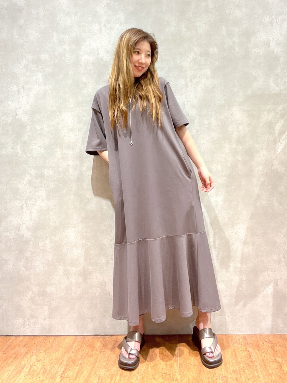 グレー系のワンピース、その他のサンダル、シルバー系のアクセサリーを着用したレディースの夏コーディネートの3枚目の写真