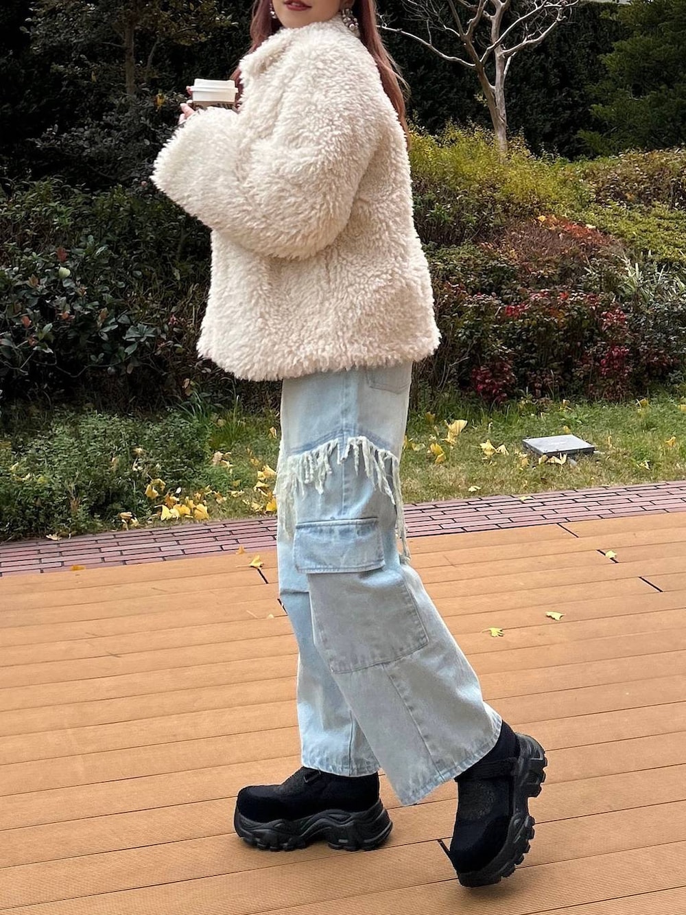 パープル系のニット/セーター、ブラック系のスニーカー、ホワイト系のその他アウターを着用したレディースの冬コーディネートの4枚目の写真