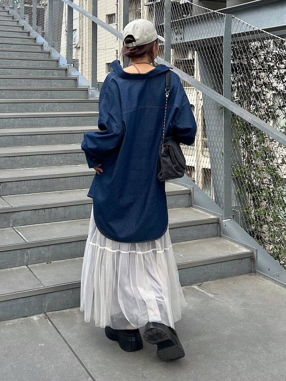 ブラック系のスニーカー、ブラック系のショルダーバッグ、ブラック系のキャミソールを着用したレディースの夏コーディネートの3枚目の写真