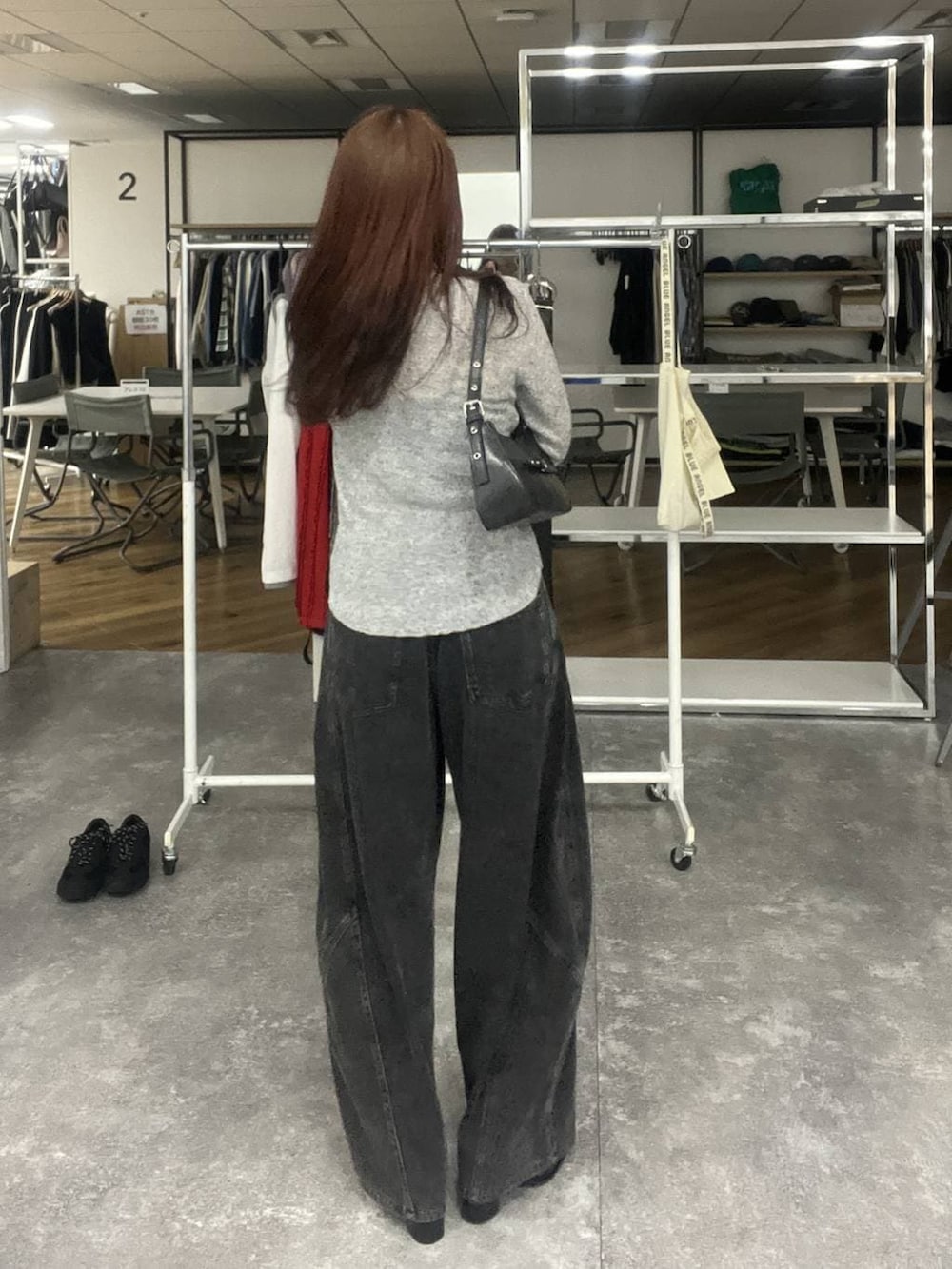 ブラック系のデニムパンツ、ブラック系のハンドバッグ、グレー系のTシャツ/カットソーを着用したレディースの冬コーディネートの3枚目の写真