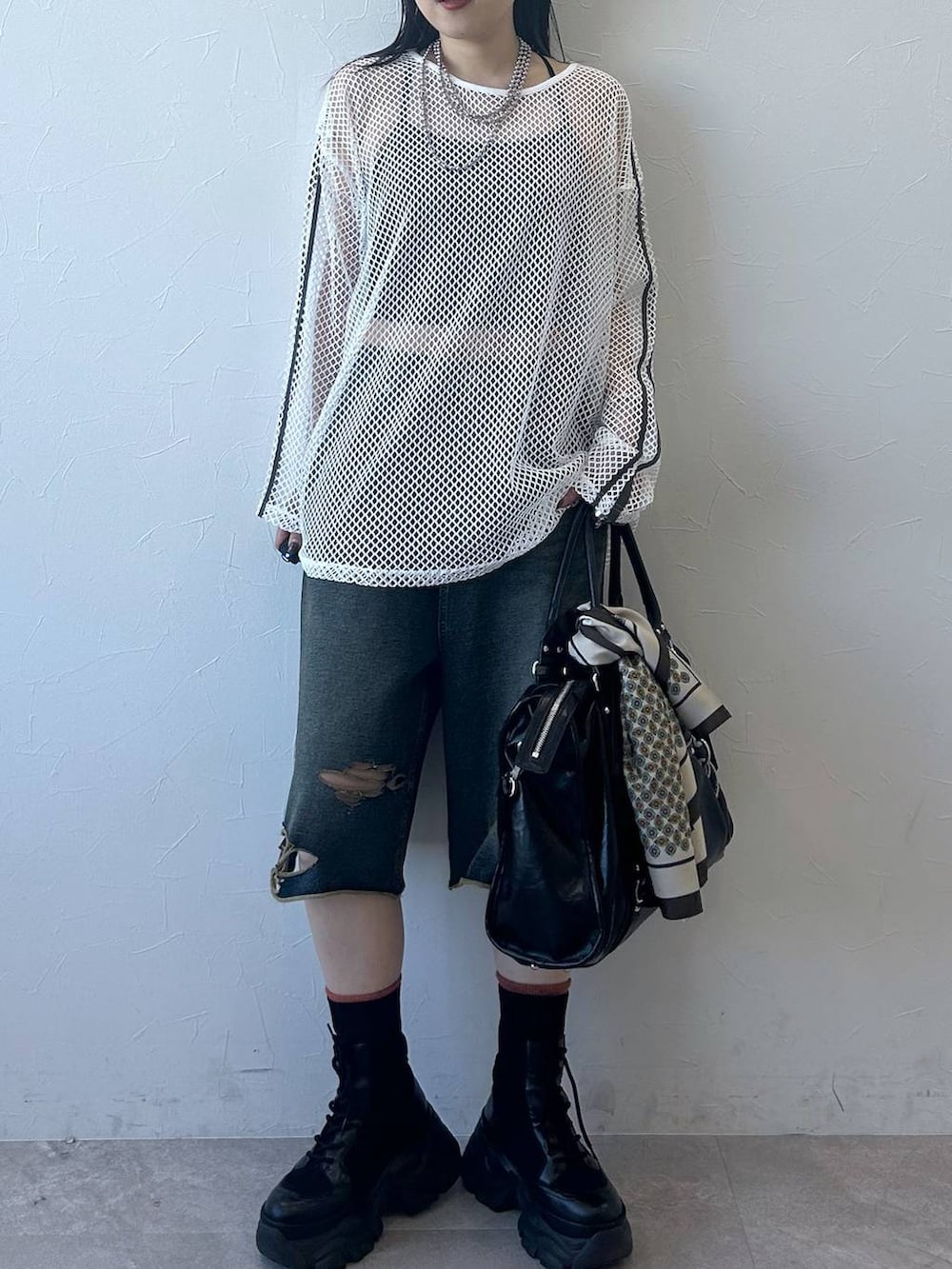 ブラック系のブーツ、ブラック系のトートバッグ、ホワイト系のTシャツ/カットソーを着用したレディースの春コーディネートの3枚目の写真