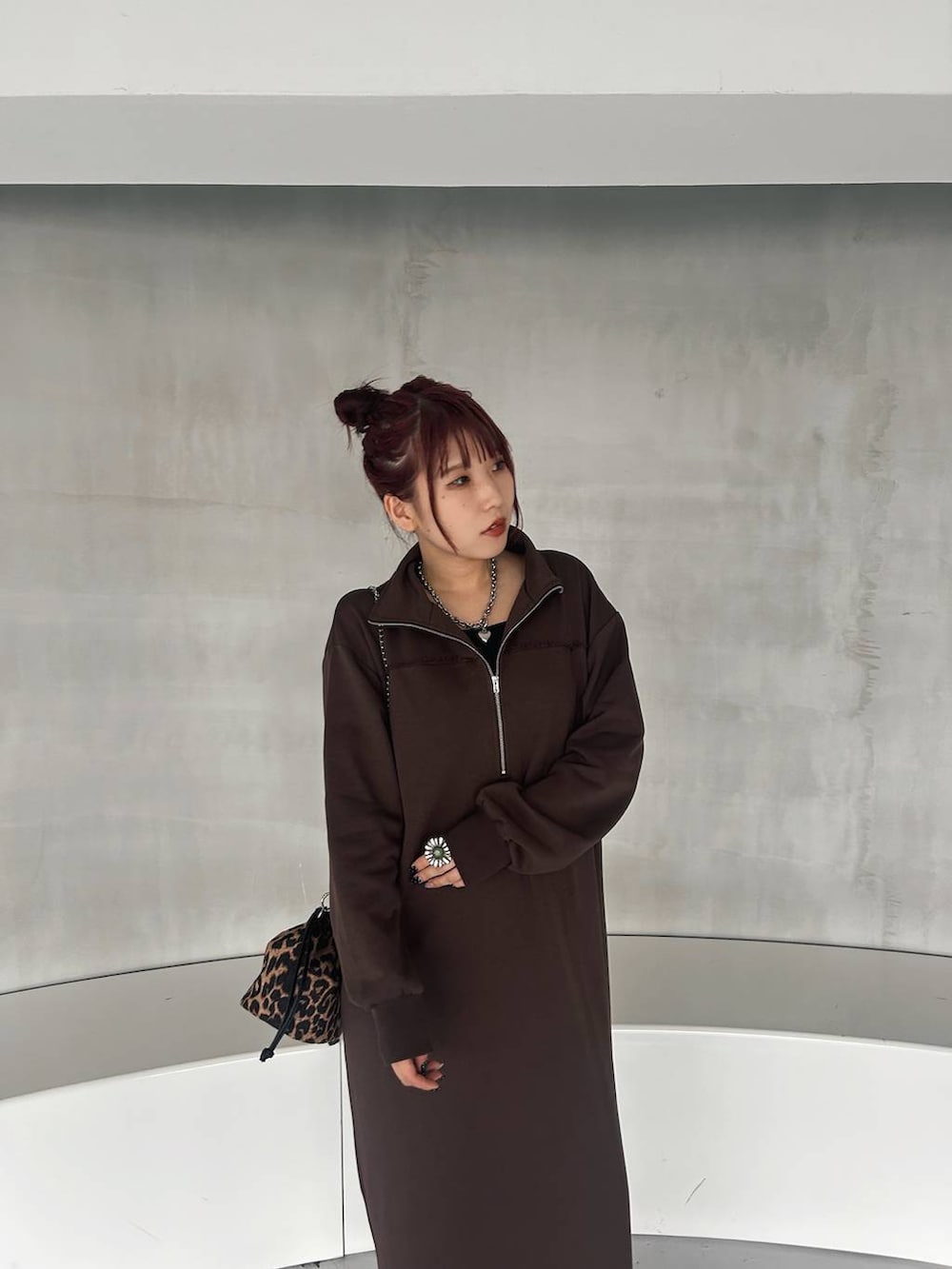 その他のハンドバッグ、ブラック系のブーツ、ブラウン系のワンピースを着用したレディースの秋コーディネートの6枚目の写真